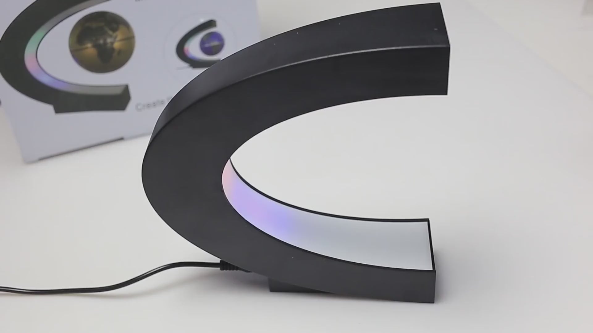 Demo clip still showing the levitating globe rotating inside the lit crescent stand.