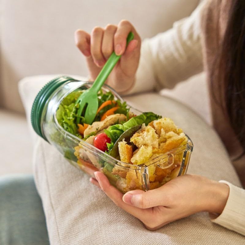 Person holding FlowFresh salad pod on lap, showing portable and ergonomic design.