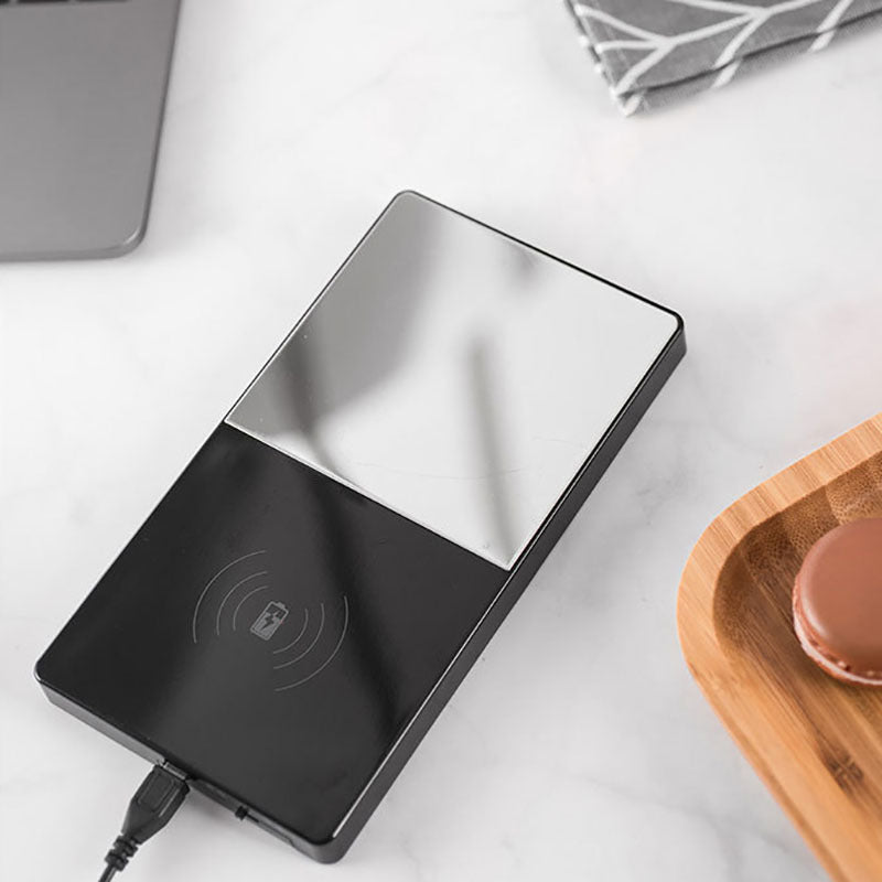 Smart mug warmer placed on a wooden tray next to accessories.