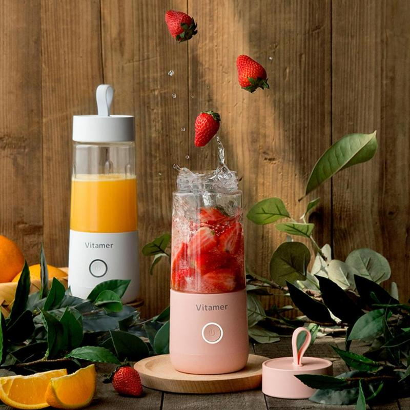 Portable smoothie blender surrounded by fresh fruit ingredients.