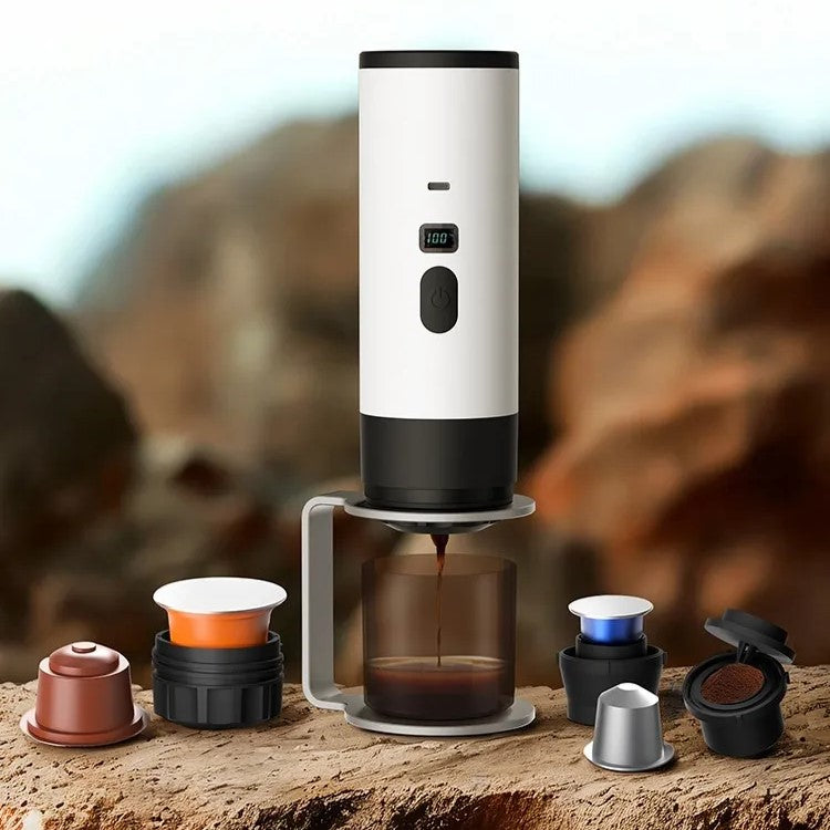 Portable coffee maker making coffee with stand, capsules, and capsule compartments in an outdoor setting.
