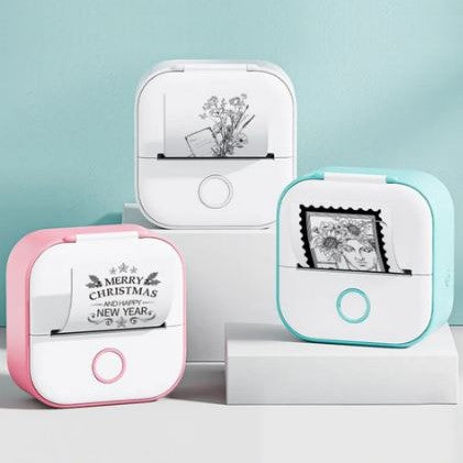 Thermal sticker printers in pink and blue on desk printing small illustrations.