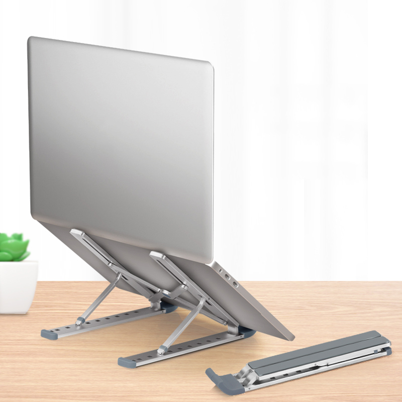 Portable adjustable laptop stand on desk with silver finish and foldable design.